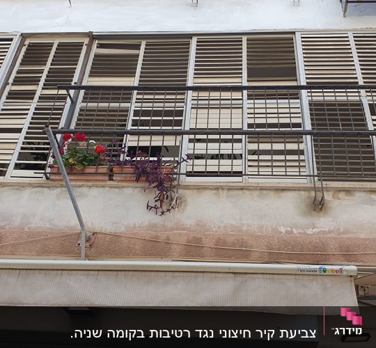 מתקן כביסה תלוי על מרפסת עם תריסים